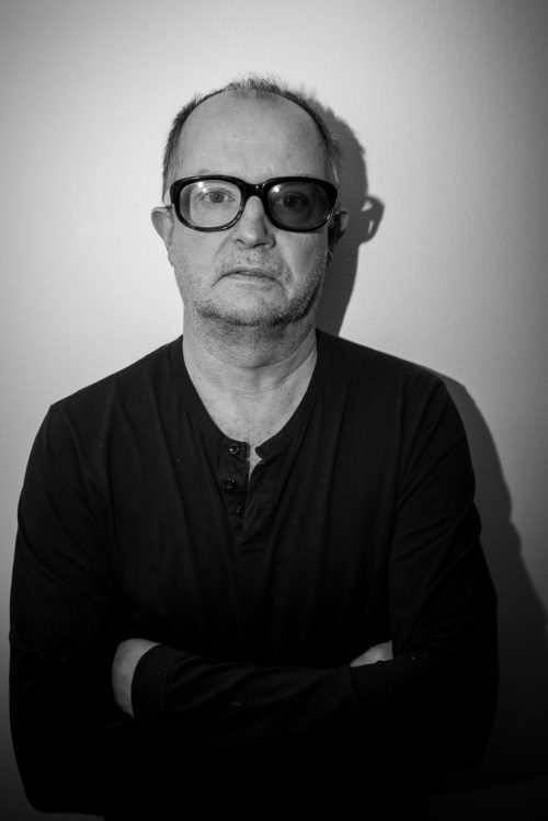 Rune Blomgren i mörka glasögon framför en vägg.