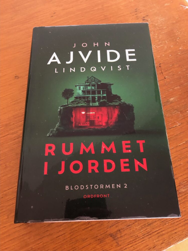 Bokomslaget till rummet i jorden, ett hus med en källare som är upplyst i rött.